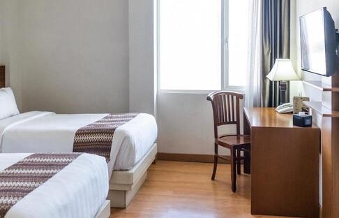 Image de la chambre d'hôtel montrant un lit